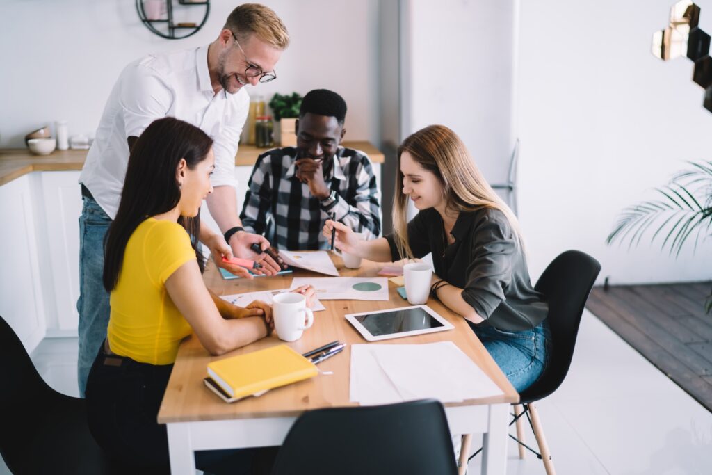 Cheerful multiracial coworkers working with business plan